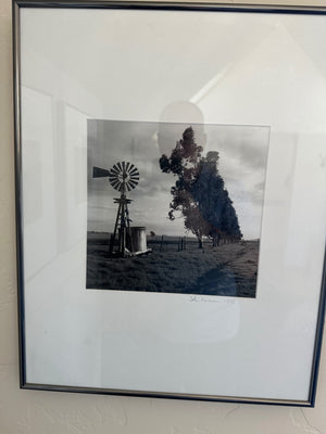 "John Harrison 1998" depicts a rustic windmill next to a water tank in a field. 16 in w x 20 h