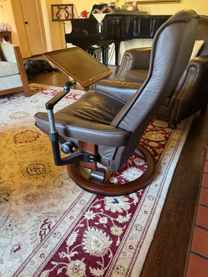 Ekornes Stressless recliner features a signature swivel base and a matching ottoman