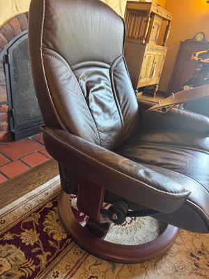 Ekornes Stressless recliner features a signature swivel base and a matching ottoman