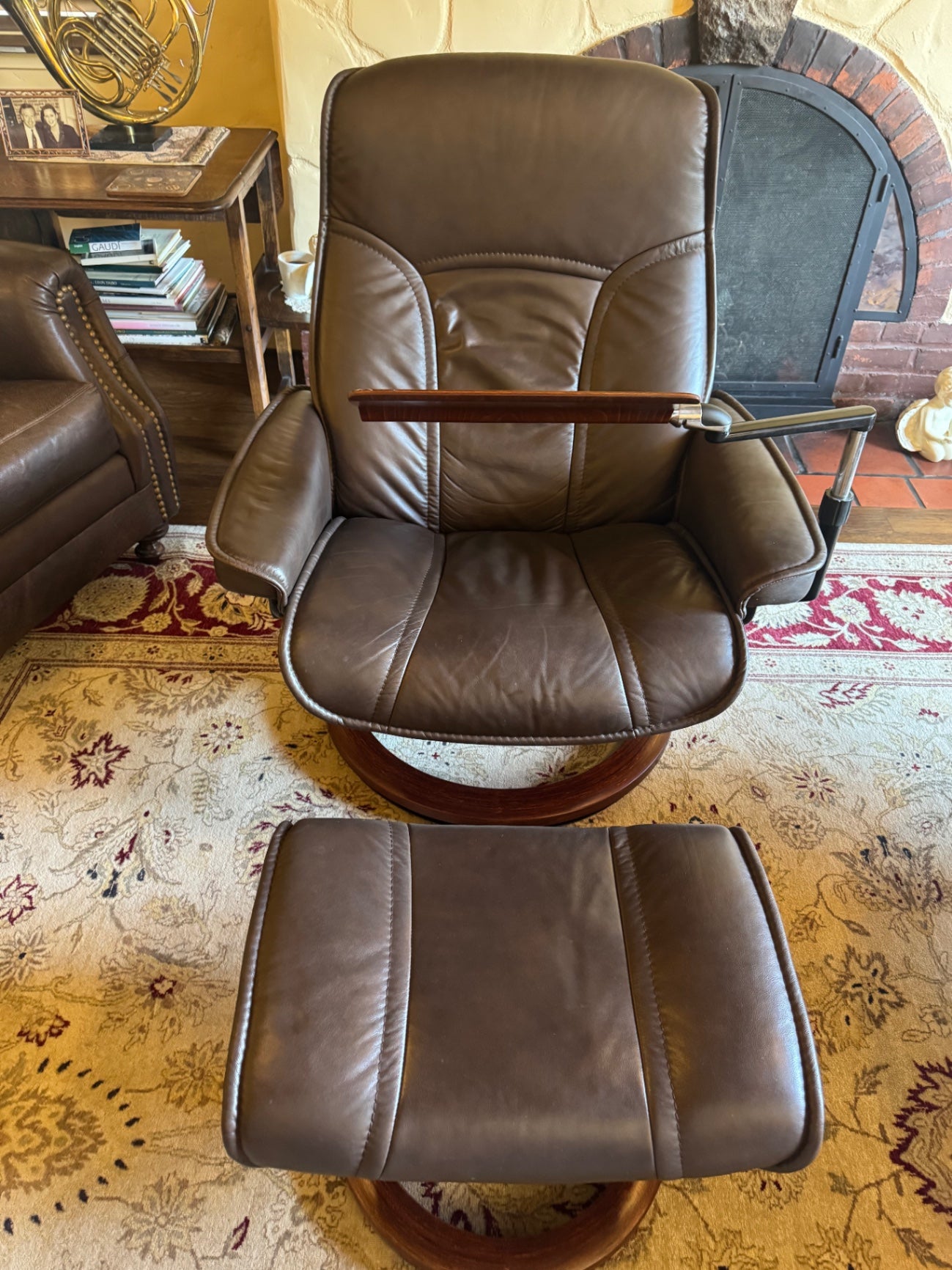 Ekornes Stressless recliner features a signature swivel base and a matching ottoman