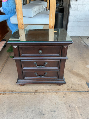 Wooden three drawer nightstand with glass top measuring 28 by by 29 x 18