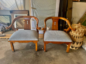 Pair of Ming style wood armchairs featuring sculptural horseshoe backs with brass detailing