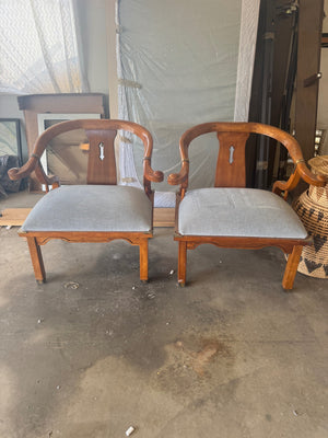 Pair of Ming style wood armchairs featuring sculptural horseshoe backs with brass detailing