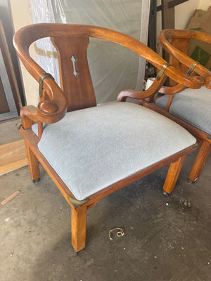 Pair of Ming style wood armchairs featuring sculptural horseshoe backs with brass detailing