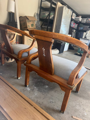 Pair of Ming style wood armchairs featuring sculptural horseshoe backs with brass detailing