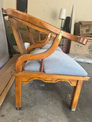 Pair of Ming style wood armchairs featuring sculptural horseshoe backs with brass detailing