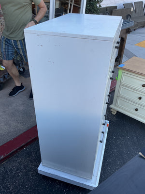 This is a chest of drawers five drawers by Eden furniture company painted tile fronts with black metal handles rolling base not included measuring 30 x 18 x 46